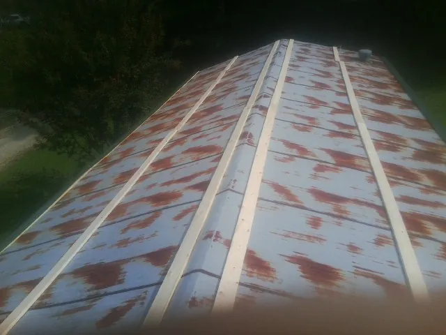 Rusted metal roof panels with new wood purlins before replacement — Storm Damage Roof Repair in Corsicana by Roofing Brothers