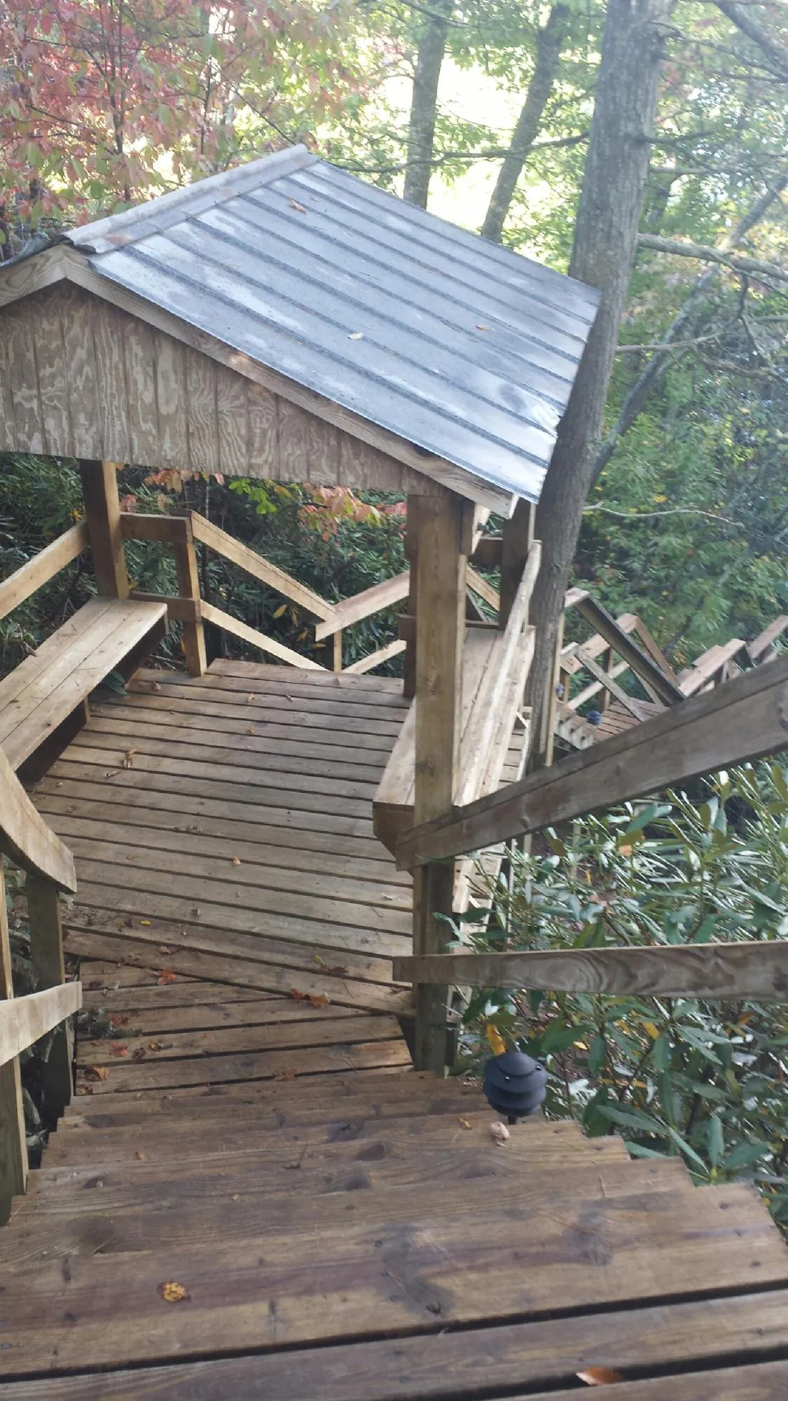 Metal roofed shelter over wooden steps on a wooded walkway — Skylight Repair & Installation work by our crew in Corsicana