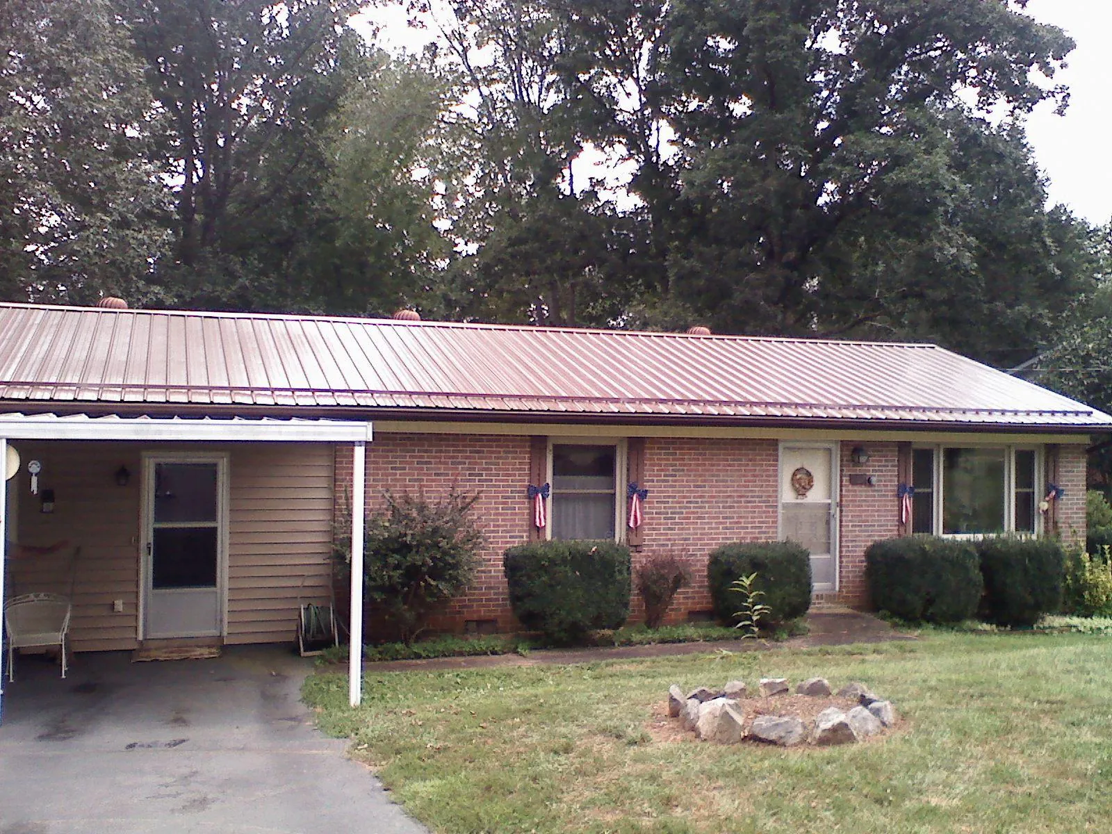 Bronze metal roof and carport on a brick ranch home — Roof Repair work by our crew in Corsicana